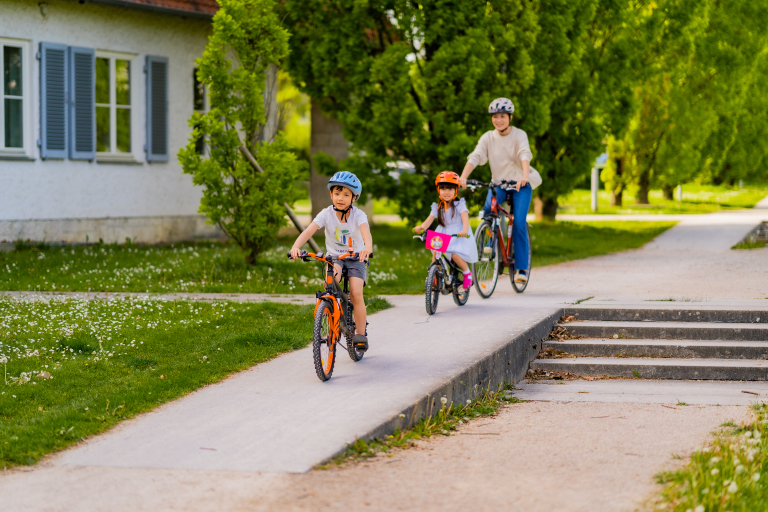 Eine Frau und zwei Kinder auf einem Fahrrad. 